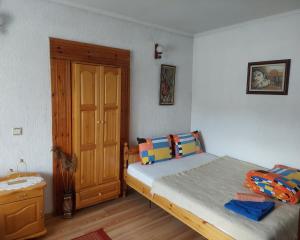 um quarto com uma cama e uma porta de madeira em Къща за гости Иглика em Trigrad