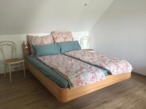 a bed with a green comforter and pillows on it at Ruhige 2-Zimmer Ferienwohnung FeWo Bodensee in Öhningen