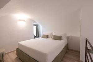 1 dormitorio con 1 cama blanca y 2 almohadas en Maison Le Graziose en Sant'Agnello