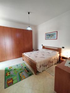 ein Schlafzimmer mit einem großen Bett und einem Teppich in der Unterkunft Appartamenti & Camere TRA SCILLA e TROPEA in San Ferdinando