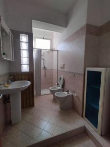 La salle de bains est pourvue d'un lavabo, de toilettes et d'une douche. dans l'établissement Appartamenti & Camere TRA SCILLA e TROPEA, à San Ferdinando