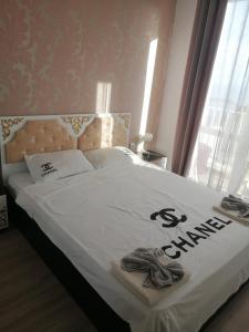 a bedroom with a bed with a white comforter at Апартамент с изглед към морето и външен басейн in Balchik