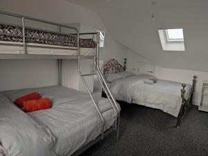 two bunk beds with red pillows in a room at Rahal Ilford in Ilford