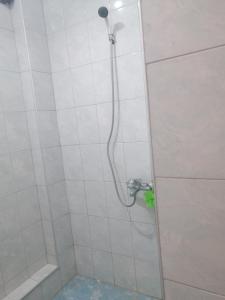 een douche met een douchekop in de badkamer bij Апартамент с изглед към морето и външен басейн in Balchik