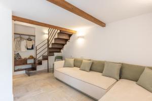 sala de estar con sofá blanco y escalera en Maison Le Graziose en Sant'Agnello