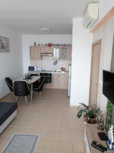 cocina y sala de estar con mesa y sillas en Апартамент с изглед към морето и външен басейн en Balchik