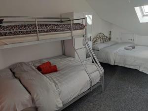 a bedroom with two bunk beds and a red pillow at Rahal Ilford in Ilford