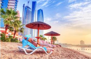 a group of chairs and umbrellas on a beach at Phenomenal Room "Sea View" in Abu Dhabi