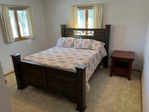 a bedroom with a bed and a table and two windows at Hunters Haven in Kimball
