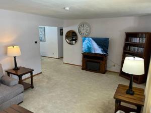 a living room with a couch and a tv at Hunters Haven in Kimball