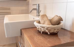 bagno con lavandino e cesto di asciugamani di RelaxHome a Santo Stefano di Magra