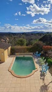 a swimming pool on a patio with chairs around it at Chez TATA in Régusse