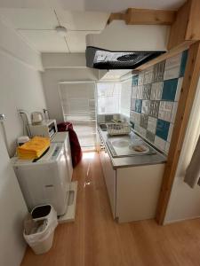 una piccola cucina con lavandino e servizi igienici di Rhodes Kagurazaka a Tokyo