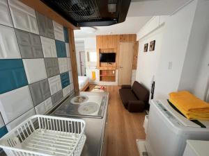una piccola cucina e un soggiorno con lavandino e piano cottura di Rhodes Kagurazaka a Tokyo