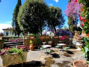 a garden with tables and chairs and flowers at Villa Nardi - Residenza D'Epoca in Florence