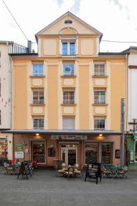 a building with tables and chairs in front of it at Haus Moselwelt Anton in Zell an der Mosel