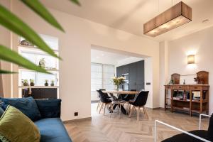 a living room with a blue couch and a table at Villa Zomerrust in De Panne