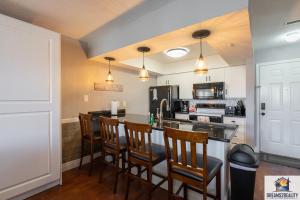 a kitchen with a bar with chairs and a stove at 2BR Walk-In Condo - Near the 76 Strip - Free WIFI - Pool - FREE TICKETS INCLUDED - CLB-3 in Branson