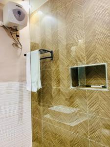 a bathroom with a shower with a mirror and a towel at De Fivez in Lagos