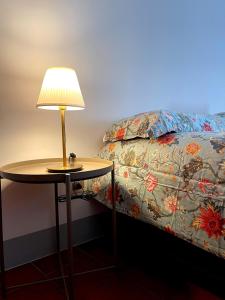 een lamp op een tafel naast een bed bij Dreaming Assisi Apartment in Assisi
