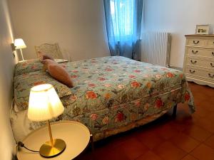 een slaapkamer met een bed en een tafel met een lamp bij Dreaming Assisi Apartment in Assisi