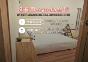 a bedroom with a bed and a sign on the wall at 寮寓Laos House三人包棟 in Xiaoliuqiu