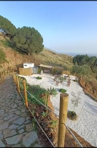 a stone walkway with a fence and chairs on a beach at Glamping Finca el Olivo in Mijas