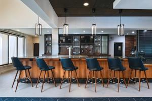 a large kitchen with a bar with blue chairs at Courtyard by Marriott San Antonio Medical Center in San Antonio