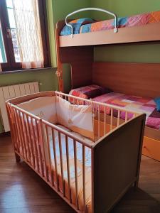 a crib in a room with two bunk beds at Casa Sabrina in Cernusco sul Naviglio