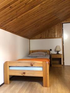 1 dormitorio con cama y techo de madera en Knieja u Andrzeja, en Lutowiska