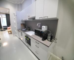 uma cozinha com armários brancos e uma bancada em Budapest Walking Street-T em Budapeste
