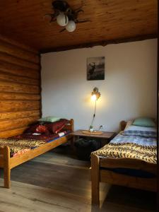 1 dormitorio con 2 camas y mesa con lámpara en Knieja u Andrzeja, en Lutowiska