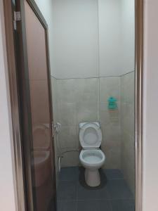 uma pequena casa de banho com WC e chuveiro em GriyaQ Homestay em Kedungwaru