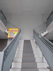 a staircase in a building with a sign on it at GriyaQ Homestay in Kedungwaru