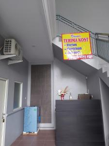 una camera con scala e un cartello sul muro di GriyaQ Homestay a Kedungwaru