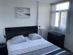 sypialnia z łóżkiem z dwiema poduszkami i oknem w obiekcie Appartement proche centre ville w Aix-en-Provence