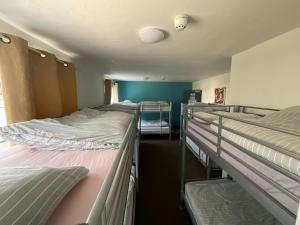 a room with three bunk beds in it at Blue Room Hostel Newquay in Newquay