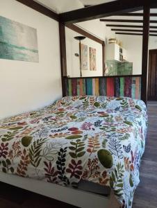 sypialnia z łóżkiem z kolorową kołdrą w obiekcie El Nial de Los Pinos w mieście Ojedo