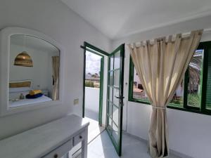 a bedroom with a bed and a mirror and a window at Piscina y Relax junto al Mar! in Corralejo