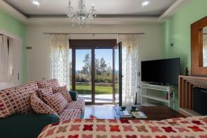 a living room with a couch and a television at Family Villa Ellis Plakias with private pool 200m to the beach walking distance to the amenities in Plakias