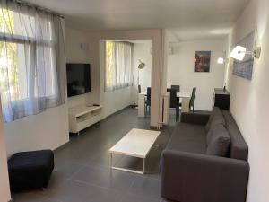salon z kanapą i stołem w obiekcie Appartement proche centre ville w Aix-en-Provence