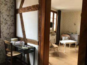 een woonkamer met een tafel en een stoel bij Tiers Lieu 59 Grand Rue in Bouxwiller