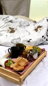 een dienblad met eten op een bed bij Glamping Quintana in Gijón