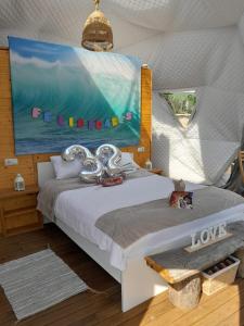 a bedroom with a bed and a painting on the wall at Glamping Quintana in Gijón