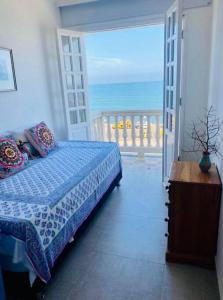 a bedroom with a bed and a view of the ocean at Apt. with rooftop & ocean view in the old city in Cartagena de Indias