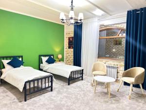 - une chambre avec 2 lits et un mur vert dans l'établissement Ayva Hotel, à Tachkent