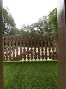 una valla en un patio con césped verde en Zen Garden Szajki Tavak, en Hosszúpereszteg