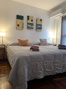 um quarto com duas camas e duas pinturas na parede em Departamento 100% equipado y excelente ubicación em Córdoba