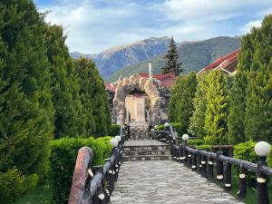 a stone walkway leading to a house with a mountain at Panorama Resort Oghuz in Oğuz
