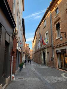 an alley with people walking down a street with buildings at Spacieux T3 Hypercentre Proche Cathédrale in Albi